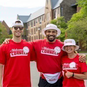 Three people in red cornell t - shirts posing for a photo.
