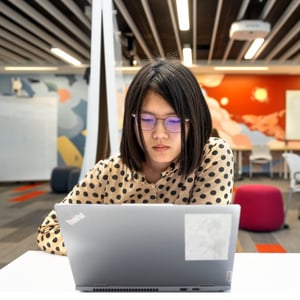 A woman sitting at a desk with a laptop in front of her.