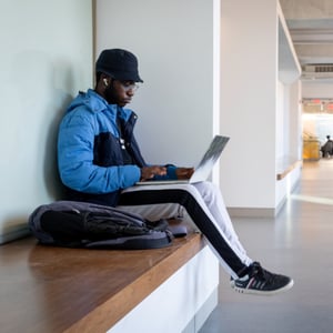 A man sitting on a bench with a laptop. A man sitting on a bench with a laptop.